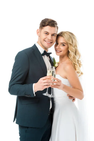 Bella sposa e bello sposo tintinnio bicchieri di champagne e guardando la fotocamera isolata su bianco — Foto stock