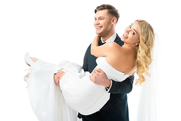 Cheerful groom holding happy bride on hands isolated on white — Stock Photo