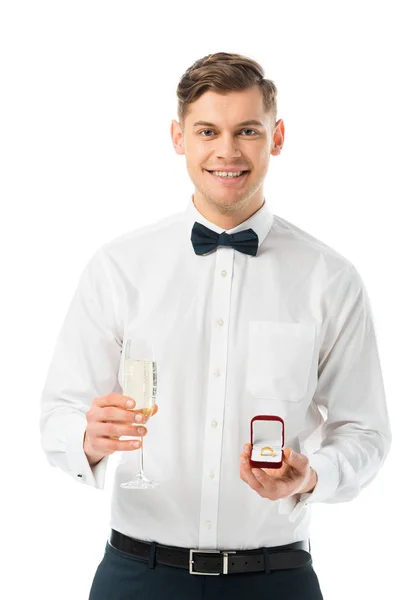 Feliz novio celebración de la copa de champán y caja de regalo con anillo de boda aislado en blanco - foto de stock