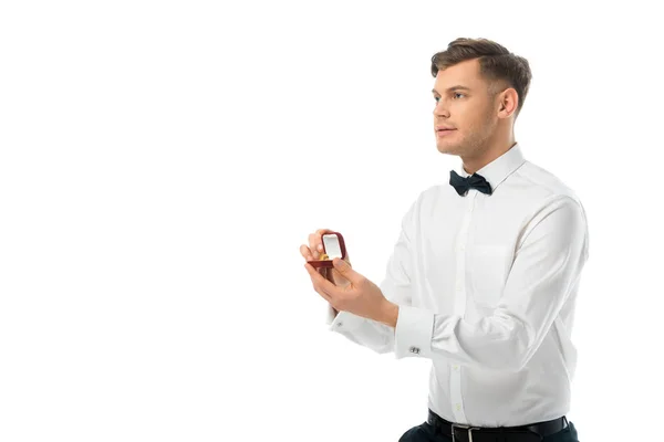 Guapo novio celebración caja de regalo con anillo de boda aislado en blanco - foto de stock