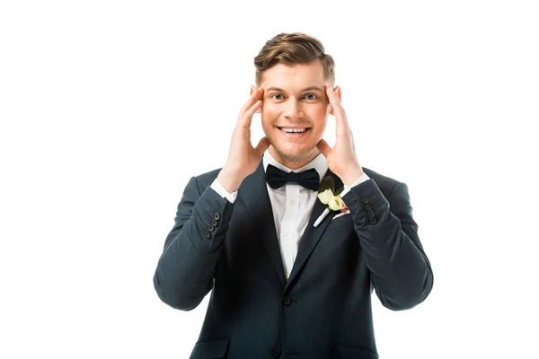 Cheerful bridegroom holding hands near head isolated on white — Stock Photo