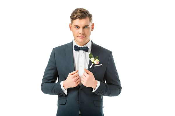 Ernsthafter Bräutigam im eleganten schwarzen Anzug, der isoliert auf weiß in die Kamera blickt — Stockfoto