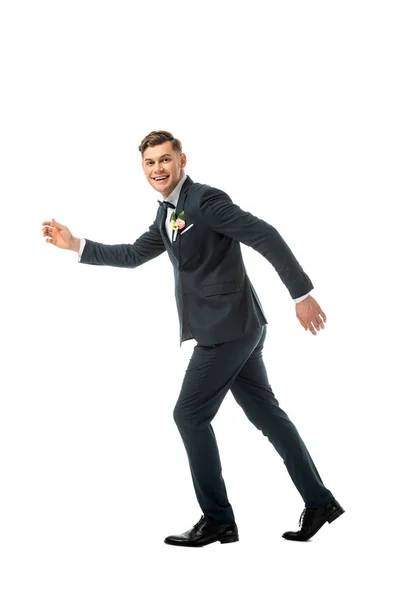 Tricky cheerful bridegroom imitating running away isolated on white — Stock Photo