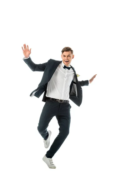 Guapo excitado novio bailando y mirando cámara aislado en blanco - foto de stock