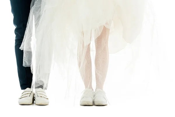 Частичный вид жениха и невесты в белых кроссовках, изолированных на белом — стоковое фото