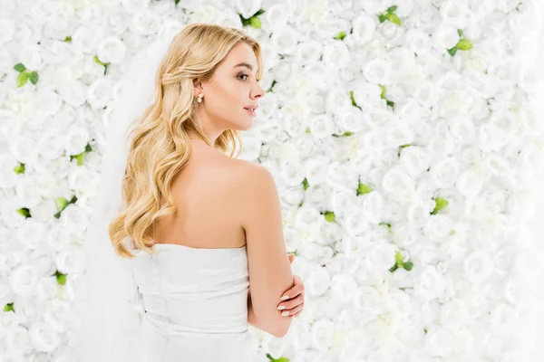 Beautiful young woman with blonde hair on white floral background — Stock Photo