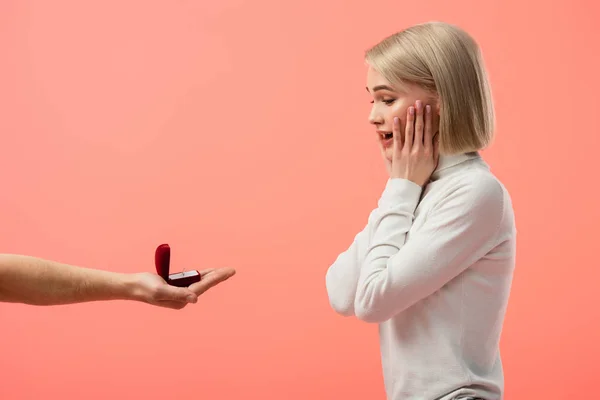 Abgeschnittene Ansicht von Mann hält Box mit Ehering in der Nähe schockierte blonde Freundin isoliert auf rosa — Stockfoto