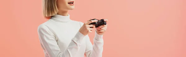 Panoramic shot of girl holding joystick while standing isolated on pink — Stock Photo