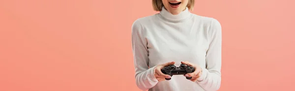 Panoramic shot of surprised girl holding joystick while standing isolated on pink — Stock Photo