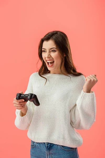 Cheerful brunette girl holding joystick while gesturing isolated on pink — Stock Photo