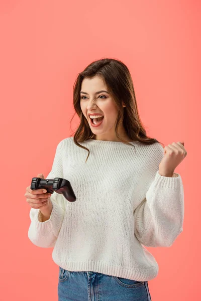 Menina morena alegre segurando joystick enquanto gesticulando isolado em rosa — Fotografia de Stock