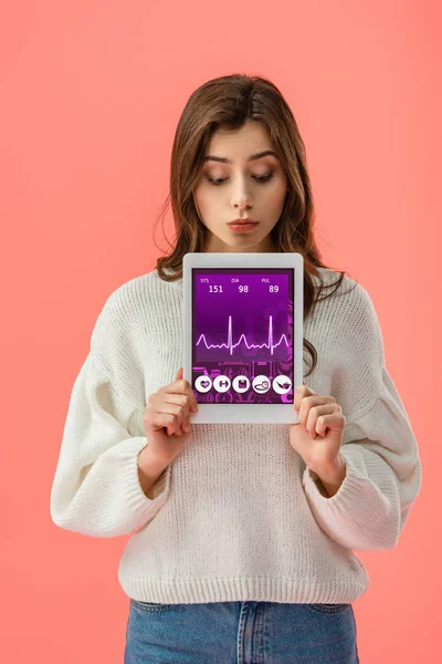 Attraktive junge Frau hält digitales Tablet mit Gesundheits-App auf dem Bildschirm isoliert auf rosa — Stockfoto