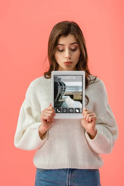 Überraschte junge Frau mit digitalem Tablet mit Ticket-App auf Bildschirm isoliert auf rosa — Stockfoto