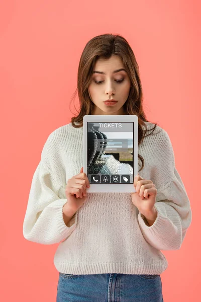 Atraente jovem segurando tablet digital com ingressos aplicativo na tela isolado em rosa — Fotografia de Stock