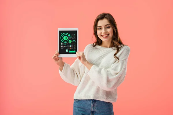 Fröhliche junge Frau hält digitales Tablet mit Diagrammen auf dem Bildschirm isoliert auf rosa — Stockfoto