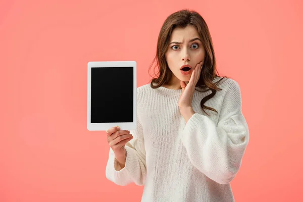 Sorprendió a la joven mujer sosteniendo tableta digital con pantalla en blanco aislada en rosa - foto de stock