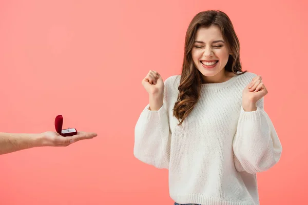 Vista parcial del hombre haciendo propuesta de matrimonio a la chica morena feliz aislado en rosa - foto de stock