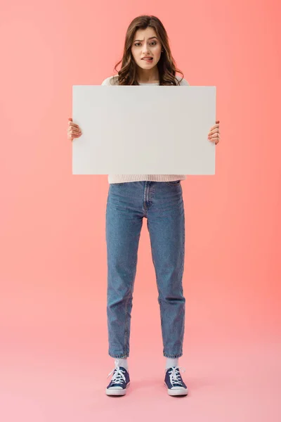 Visão comprimento total da mulher bonita e triste segurando placa vazia com espaço de cópia isolado em rosa — Fotografia de Stock
