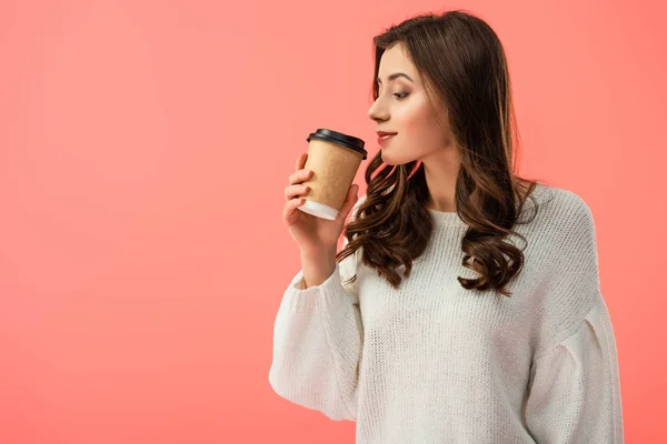 Belle jeune femme en pull blanc tenant tasse en papier isolé sur rose — Photo de stock