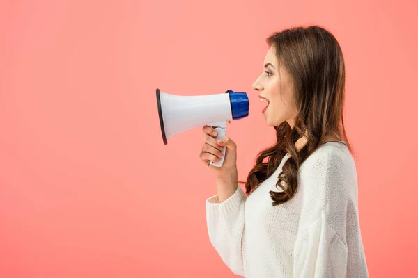 Seitenansicht der brünetten Frau in weißem Pullover schreit in Megafon isoliert auf rosa — Stockfoto