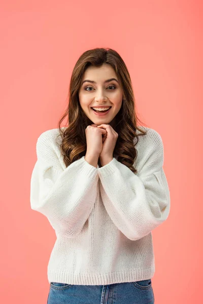 Sonriente y hermosa mujer en suéter blanco mirando a la cámara aislada en rosa - foto de stock