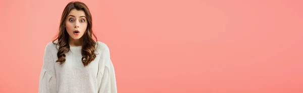 Plano panorámico de mujer sorprendida y hermosa en suéter blanco mirando a la cámara aislada en rosa - foto de stock