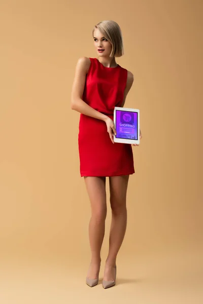 Visão completa da mulher em vestido vermelho segurando tablet digital com aplicativo de compras na tela — Fotografia de Stock