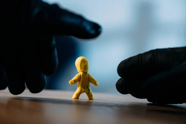 Dieb mit schwarzen Handschuhen stiehlt gelbes Spielzeug — Stockfoto