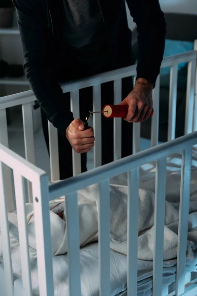 Частковий погляд на кримінальний запалювальний динаміт біля дитини в дитячому ліжечку — стокове фото
