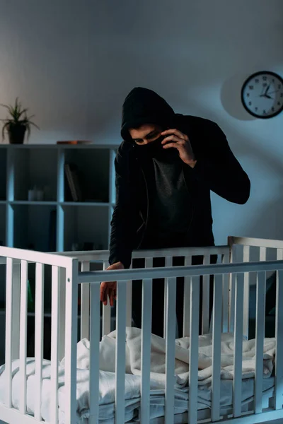 Criminale in maschera che parla sullo smartphone mentre rapisce un bambino — Foto stock