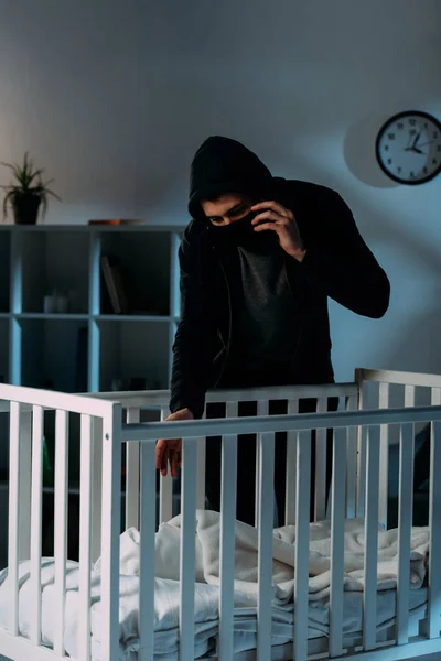 Criminal in mask talking on smartphone while kidnapping child — Stock Photo