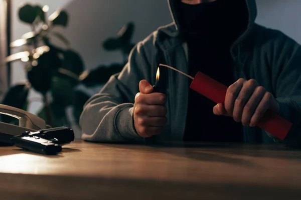 Vista recortada de criminal en máscara encendiendo dinamita en la habitación - foto de stock