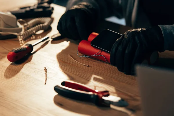 Cropped view of terrorist in leather gloves making bomb — Stock Photo