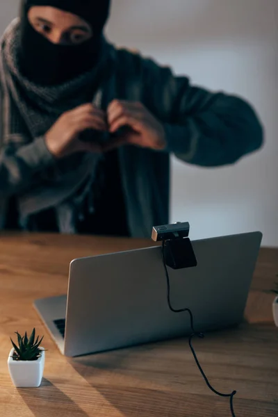 Terrorist in black mask showing heart sign in video chat — Stock Photo