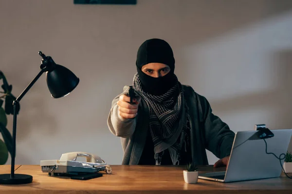 Злой террорист в черной маске целится в камеру — стоковое фото