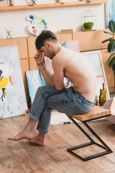 Tired half-naked artist sitting on chair in painting studio — Stock Photo