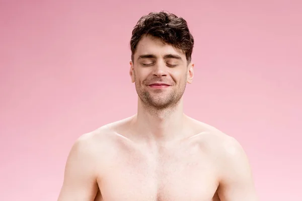 Handsome, smiling brunette man with closed eyes on pink — Stock Photo