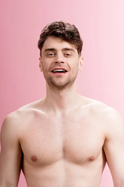 Handsome, smiling brunette man looking at camera on pink — Stock Photo