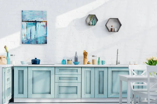 Innenraum einer hellen, eleganten Küche mit Geschirr, Dekor und Sonnenlicht — Stockfoto