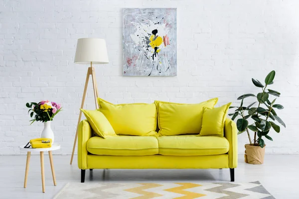 Интерьер уютной гостиной с ярко-желтыми элементами, декором и ретро-телефоном — стоковое фото