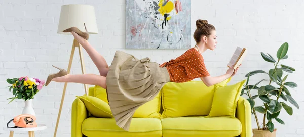 Panoramic shot of elegant young woman levitating in air while reading book — Stock Photo