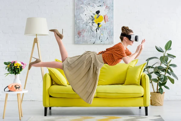 Side view of elegant young woman flying in air while wearing virtual reality headset — Stock Photo