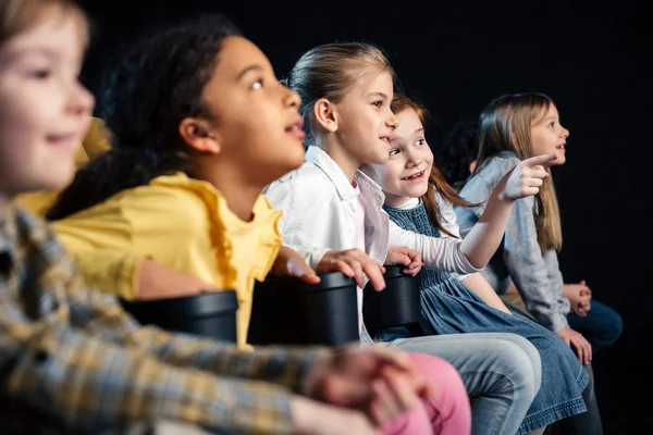 Enfoque selectivo de amigos multiculturales viendo películas en el cine - foto de stock