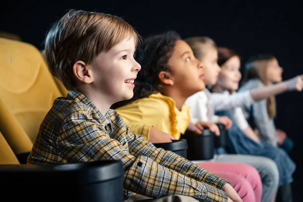 Selective focus of multicultural friends watching movie at cinema — Stock Photo