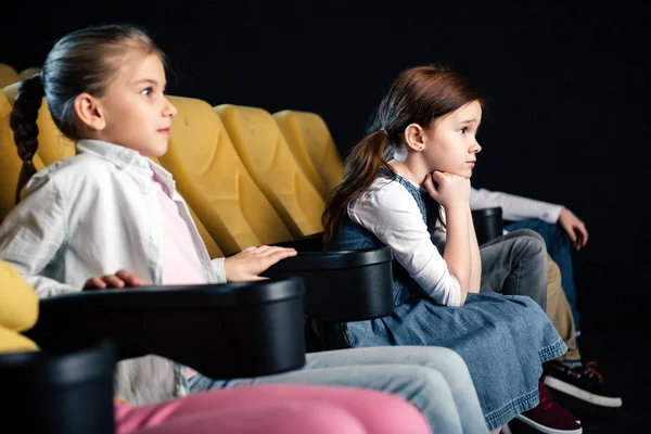 Mignon attentif enfants regarder film dans cinéma ensemble — Photo de stock