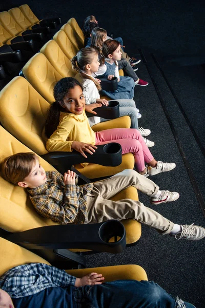 Sorrindo amigos multiétnicos assistindo filme no cinema juntos — Fotografia de Stock