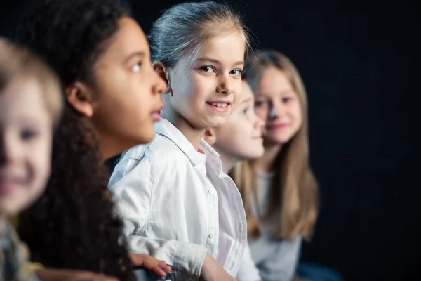 Foyer sélectif des enfants adorables assis dans le cinéma et regarder le film — Photo de stock