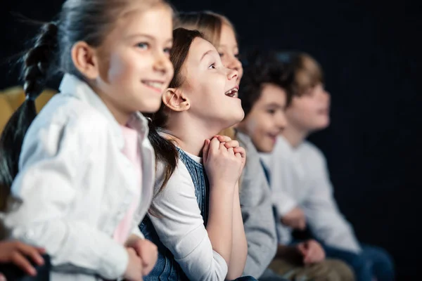 Messa a fuoco selettiva di amici eccitati seduti al cinema e guardare film — Foto stock