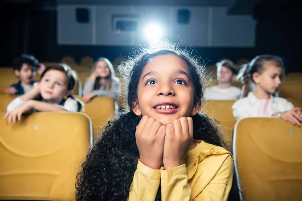 Foyer sélectif de fille afro-américaine adorable regarder un film au cinéma avec des amis — Photo de stock