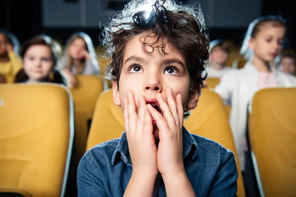 Selective focus of surprised mixed race boy watching movies together with friends — Stock Photo